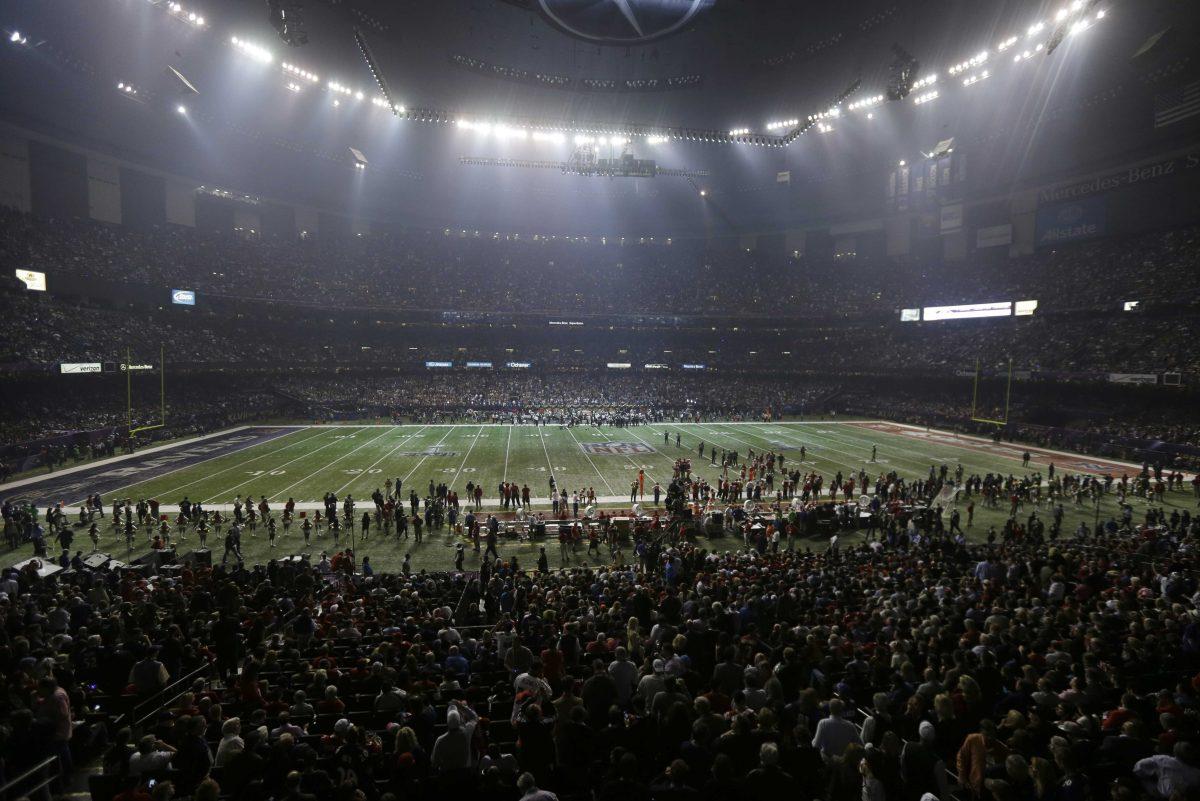 Fans and members of the Baltimore Ravens and the San Francisco 49ers wait for power to return in the Superdome during an outage in the second half of the NFL Super Bowl XLVII football game, Sunday, Feb. 3, 2013, in New Orleans. (AP Photo/Gerald Herbert)