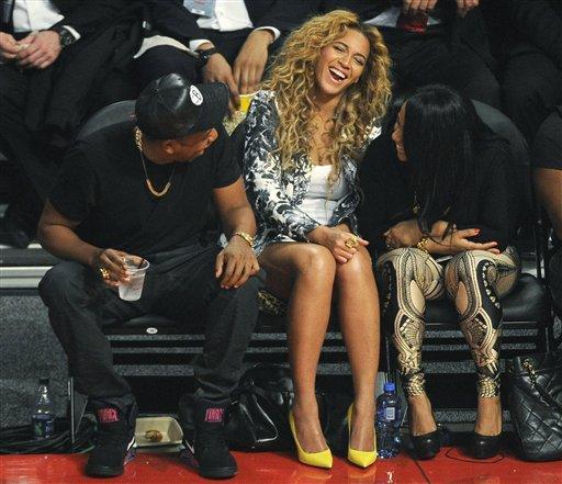 Jay Z, left, and Beyonce talk to another court-side spectator during the first half of the NBA All-Star basketball game Sunday, Feb. 17, 2013, in Houston. (AP Photo/Pat Sullivan)
 