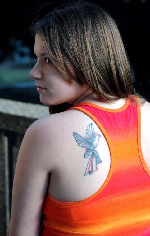 Animal Science freshman Katie Picou stands on a balcony overlooking Memorial Oak Grove Tuesday, Feb. 26, 2013. Her tattoo is a tribute to both of her grandfathers.
 