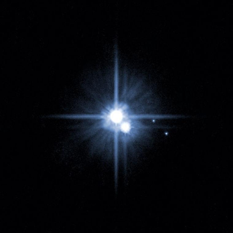 FILE - This file image provided by NASA on Feb. 22, 2006 from it's Hubble Space Telescope shows Pluto and three of it's five moons. An online vote to name Pluto's two newest, itty-bitty moon concluded Monday, Feb. 25, 2013, and the winner is Vulcan, a name suggested by actor William Shatner, who played Capt. Kirk in the original "Star Trek" TV series. (AP Photo/NASA, File)
 