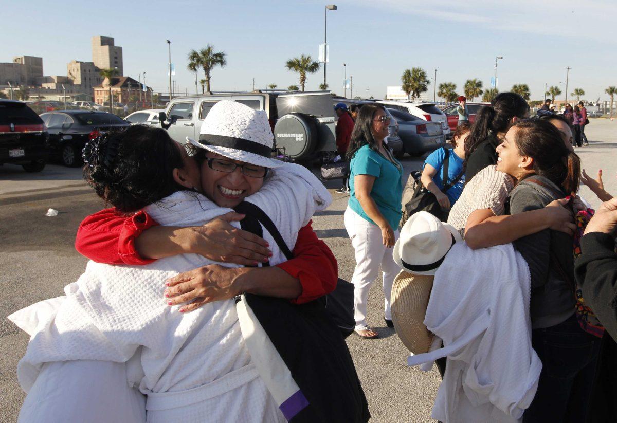 Patricia Wagner, right, hugs her sister Mercedes Perez de Colon,as their group is reunited after taking separate buses from Mobile, Ala., where the disabled Carnival ship Triumph docked, on Friday February 15, 2013 in Galveston, Texas. Hundreds of passengers opted to take an eight-hour bus ride to Galveston from Mobile. Galveston is the home port of the ill-fated ship, which lost power in an engine-room fire Sunday some 150 miles off Mexico's Yucatan peninsula. (AP Photo/The Galveston County Daily News, Jennifer Reynolds) MANDATORY CREDIT