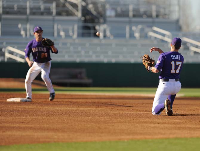 LSU sophomore Jared Foster (right) tosses the ball to teammate Casey Yocom (left) during practice on Friday, Feb. 1, 2013 at Alex Box Stadium.
 