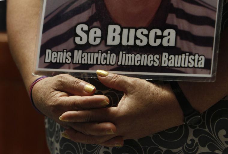 FILE - In this Oct. 28, 2012 file photo, a member of a caravan of Central American mothers hold a photograph of her disappeared child during a Mass at the Basilica of Guadalupe in Mexico City. The sign reads in Spanish "Looking for Denis Mauricio Jimenes Bautista." A new Human Rights Watch report released on Wednesday, Feb. 20, 2013 calls Mexico&#8217;s anti-drug offensive &#8220;disastrous&#8221; and cites 249 cases of disappearances, about 149 of which include evidence of being carried out by the military or law enforcement. The report says the forced disappearances follow a pattern in which security forces detain people without warrants at check-points, homes, workplaces or in public. Human Rights Watch criticizes former President Felipe Calderon for ignoring the problem, calling it &#8220;the most severe crisis of enforced disappearances in Latin America in decades.&#8221; (AP Photo/Marco Ugarte, file)
 