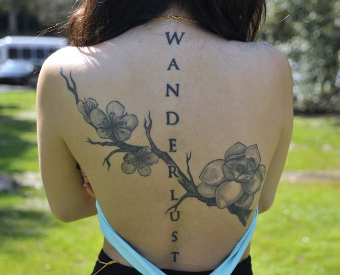 Pre-nursing freshman Julie Liu shows off her back tattoo on Sunday, Feb. 24, 2013 on the Parade Ground. The cherry blossum is the native flower of her parents' homeland, Taiwan, and the magnolia is the Louisiana state flower, which is where Liu was born. The branch connecting them represents the connection between her two cultures.
 