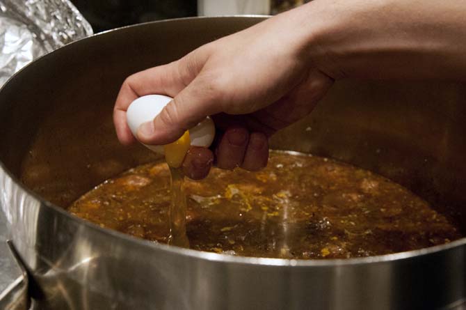 A raw eggs gets cracked into the pot of steaming hot gumbo to have there be poached eggs in the gumbo mixture at the gumbo Viking cooking class at the Hilton Hotel on Jan. 31, 2013.
 