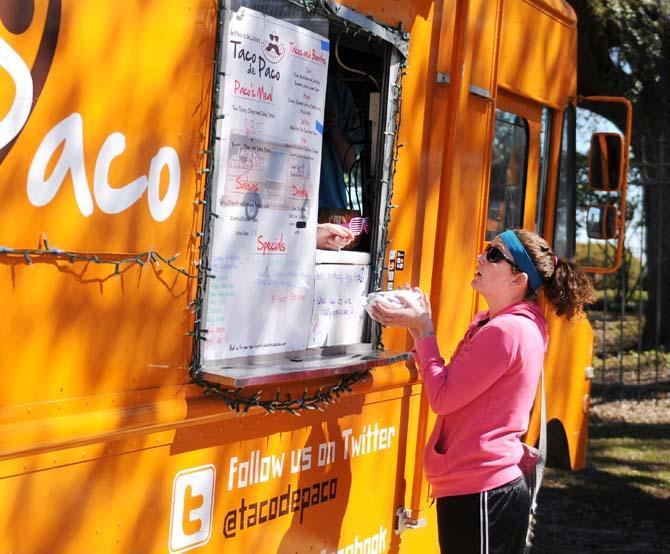 A food lover grabs a burrito from Taco de Paco on Feb. 16, 2013, at the Baton Rouge Food Truck Wround-Up near Perkins Palms.
 