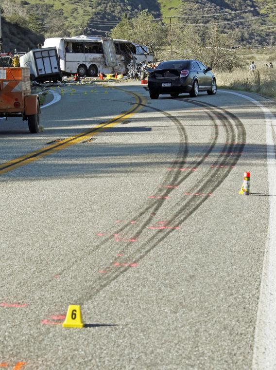 Skid marks from a tour bus are seen Monday, Feb. 4, 2013, after the bus, background, collided with two other vehicles and crashed Sunday, killing at least eight people and injuring 38, on Highway 38 just north of Yucaipa, Calif. The bus was carrying a tour group from Tijuana, Mexico. (AP Photo/Reed Saxon)
 