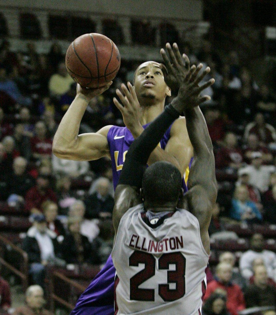 LSU's Charles Carmouche, top, drives for the basket as South Carolina's Bruce Ellington (23) tries to block during the first half of their NCAA college basketball game on Thursday, Feb. 14, 2013, in Columbia, S.C. (AP Photo/Mary Ann Chastian)