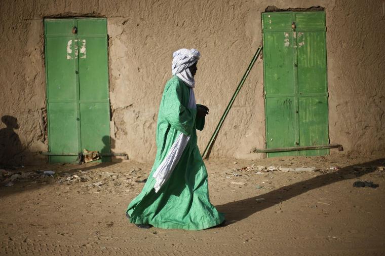 A Malian man dressed in green walks between green doors of closed shops in Gao, northern Mali, Tuesday Feb. 5, 2013. Troops from France and Chad moved into Kidal in an effort to secure the strategic north Malian city, a French official said Tuesday, as the international force put further pressure on the Islamic extremists to push them out of their last major bastion of control in the north.(AP Photo/Jerome Delay)
 