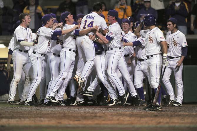 Junior infielder Christian Ibarra (14) jumps into his teammates Thursday, Feb. 21, 2013 after he hit a home run to tie the game with BYU in Alex Box Stadium. The Tigers won, 6-5.
 