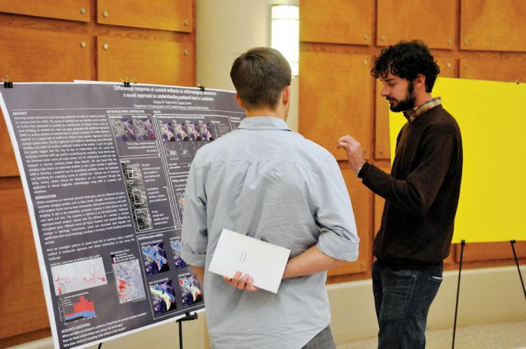 Oceanography graduate student Andrew Tweel explains the contents of his poster to another student Friday, Feb. 15, 2013, in the Energy Coast and Environment building.
 