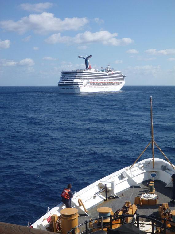 In this image released by the U.S. Coast Guard on Feb. 11, 2013, the Coast Guard Cutter Vigorous patrols near the cruise ship Carnival Triumph in the Gulf of Mexico, Feb. 11, 2013. The Carnival Triumph has been floating aimlessly about 150 miles off the Yucatan Peninsula since a fire erupted in the aft engine room early Sunday, knocking out the ship's propulsion system. No one was injured and the fire was extinguished. (AP Photo/U.S. Coast Guard- Lt. Cmdr. Paul McConnell)
 