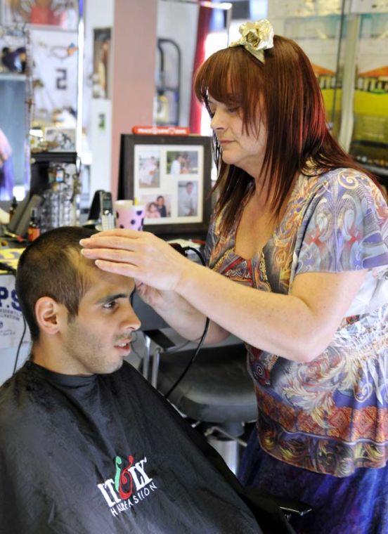 Christine Genevieve Carlino, owner of Hair Factory on Nicholson Drive, cuts hair Saturday, Feb. 2, 2013, for Juan Diaz, a regular customer at the local barber shop.
 