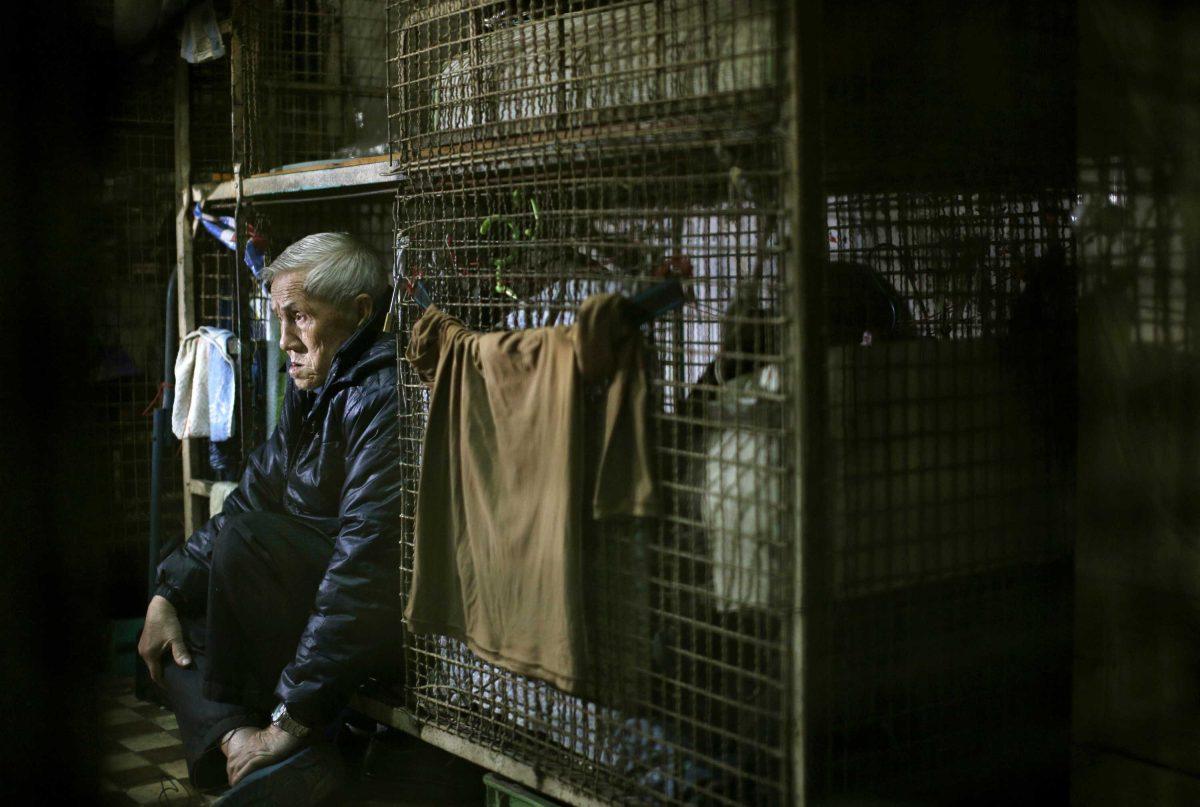 In this Jan. 25, 2013 photo, 77-year-old Yeung Ying Biu sits inside his 1.5 square meter (16 square feet) cage, which he calls home, in Hong Kong. For many of the richest people in Hong Kong, one of Asia's wealthiest cities, home is a mansion with an expansive view from the heights of Victoria Peak. For some of the poorest, home is a metal cage. Some 100,000 people in the former British colony live in what's known as inadequate housing, according to the Society for Community Organization, a social welfare group. (AP Photo/Vincent Yu)