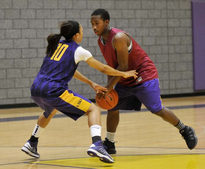 Kinesiology student Blake Hicks (right) dribbles around LSU senior guard Adrienne Webb (10) Jan. 29, 2013 in the Basketball Practice Facility.
 