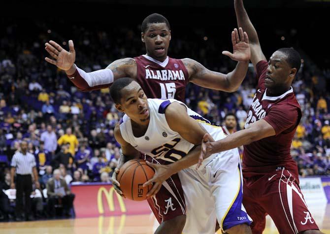 LSU senior guard Charles Carmouche (0) keeps the ball away from Alabama sophomore forward Nick Jacobs (15) and senior guard Andrew Steele (22) Saturday, Feb. 23, 2013 during the Tigers' 97-94&#160;triple overtime victory against the Crimson Tide.
 