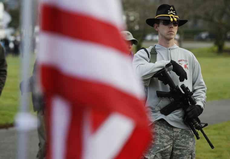 Ryan Brooks, of Shelton, Wash., holds his AR-15 rifle as he attends a gun rights rally Friday, Feb. 8, 2013, at the Capitol in Olympia, Wash. Several hundred people gathered and spoke against proposed legislation at both the state and national levels aimed at curbing gun violence. (AP Photo/Ted S. Warren)
 