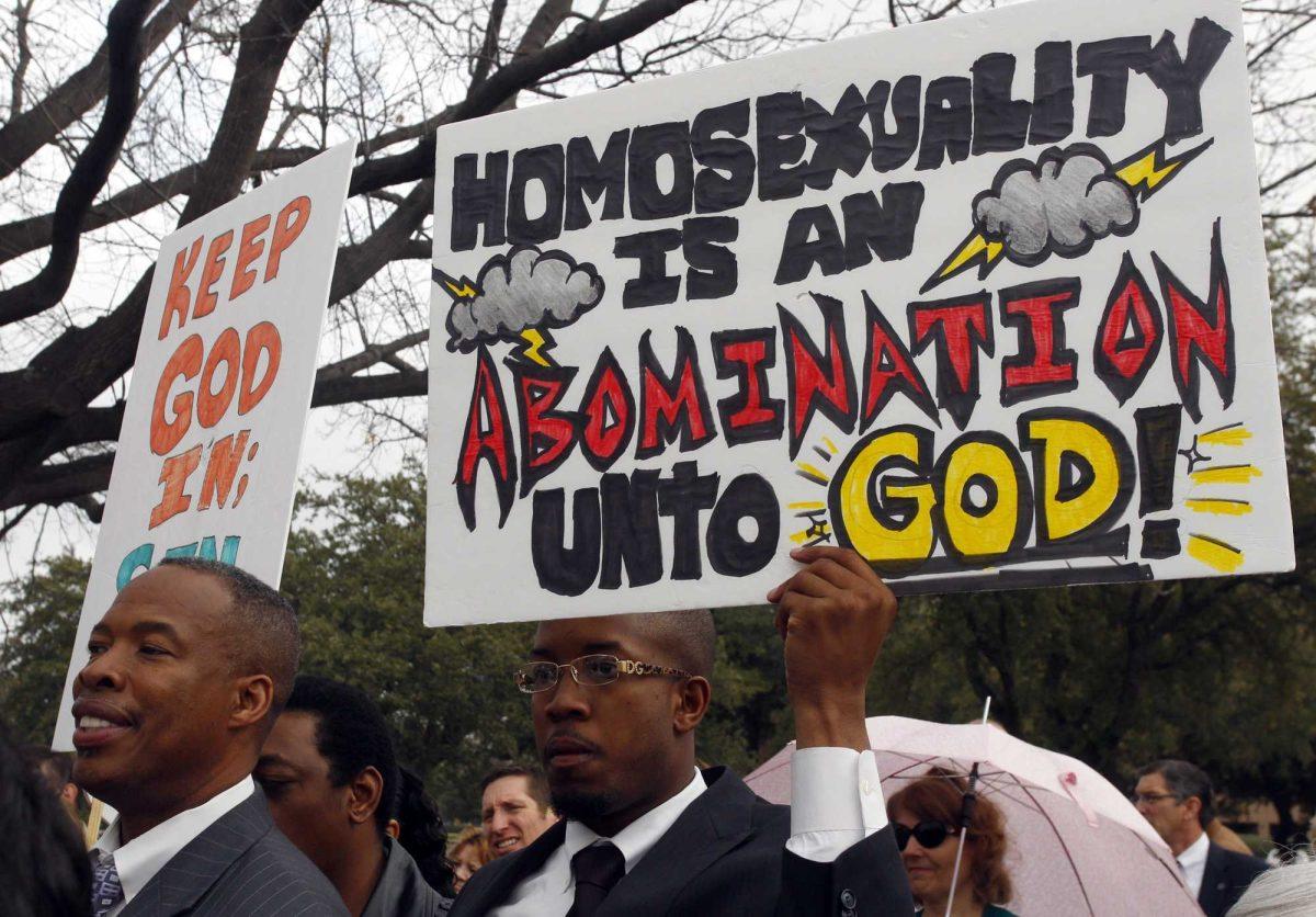 Pastor Alvin Fuller, left, of God's Final Warning Ministries of Lancaster, Texas, stands next to his son Gershom Fuller who is holding a sign at they attend the &#8220;Save Our Scouts&#8221; Prayer Vigil and Rally in front of the Boy Scouts of America National Headquarters in Irving, Texas, Wednesday, February 6, 2013. The Boy Scouts of America said Wednesday it needed more time before deciding whether to move away from its divisive policy of excluding gays as scouts or adult leaders. (AP Photo/Richard Rodriguez)