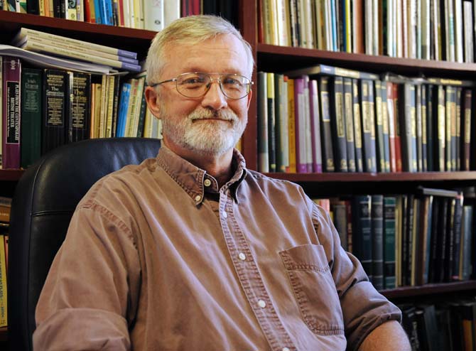 English professor and faculty athletics representative William Demastes sits in front of his collection of books on Feb. 20, 2013, in his office at Allen Hall.
 