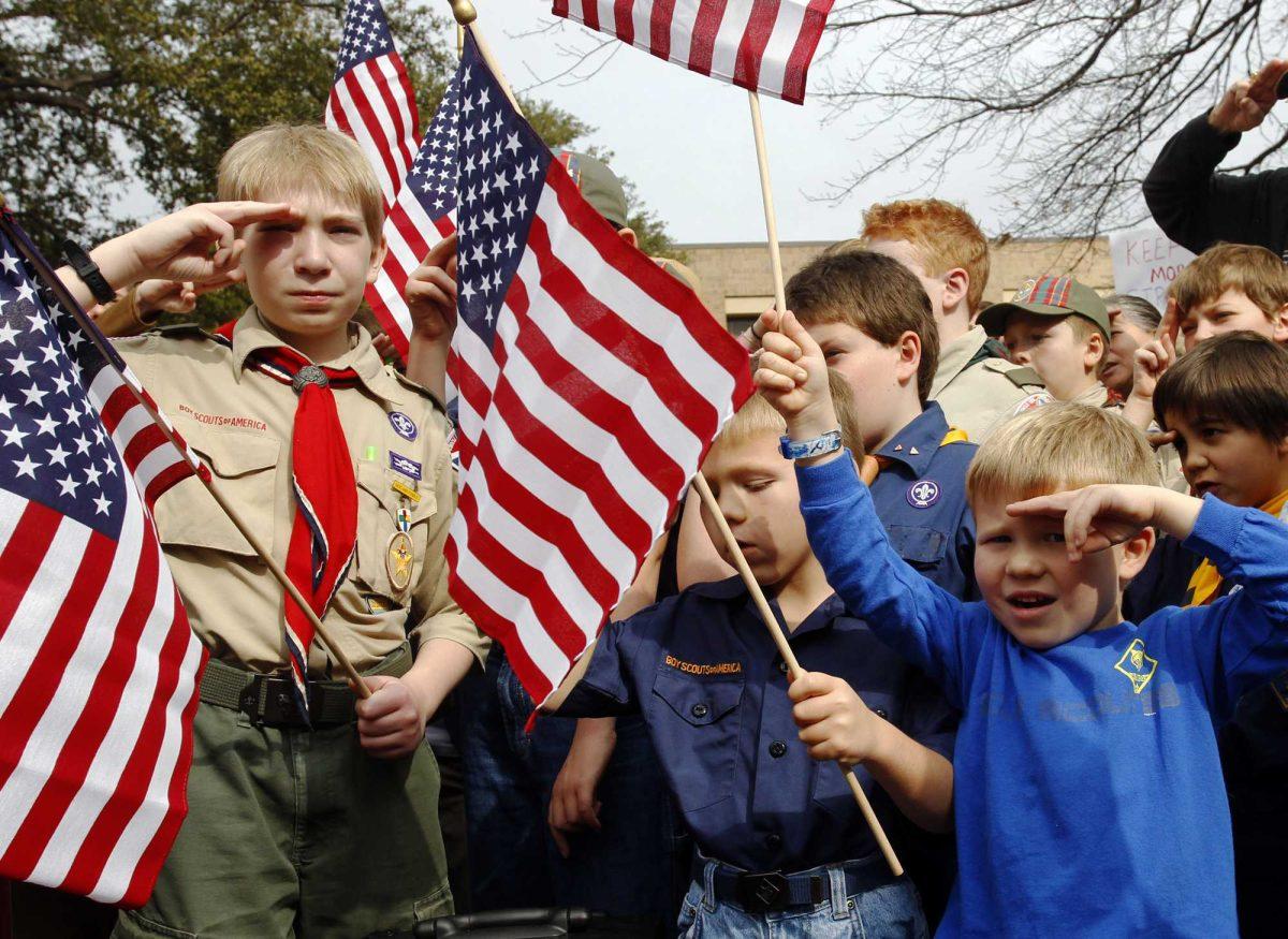 File - In this Feb 6, 2013 file photo, from left, Joshua Kusterer, 12, Nach Mitschke, 6, and Wyatt Mitschke, 4, salute as they recite the pledge of allegiance during the &#8220;Save Our Scouts&#8221; Prayer Vigil and Rally in front of the Boy Scouts of America National Headquarters in Dallas, Texas. In terms of passion and drama, it promises to be a campaign that rivals any big election. For the next 14 weeks, the Boy Scouts of America will be the focus of prayers, petitions and pressure tactics aimed at swaying a planned vote by 1,400 Scout leaders on whether to ease the policy banning gays from membership. (AP Photo/Richard Rodriguez, File)