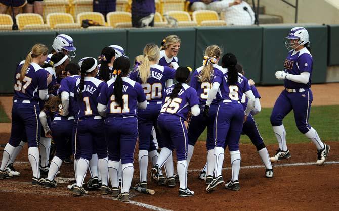 The LSU softball team celebrates on Friday, Feb. 8, 2013 as junior Tammy Wray runs into home plate during the tiger's first game of the season against North Carolina at Tiger Park.
 