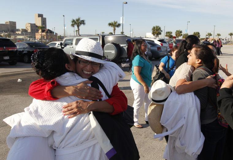 Patricia Wagner, right, hugs her sister Mercedes Perez de Colon,as their group is reunited after taking separate buses from Mobile, Ala., where the disabled Carnival ship Triumph docked, on Friday February 15, 2013 in Galveston, Texas. Hundreds of passengers opted to take an eight-hour bus ride to Galveston from Mobile. Galveston is the home port of the ill-fated ship, which lost power in an engine-room fire Sunday some 150 miles off Mexico's Yucatan peninsula. (AP Photo/The Galveston County Daily News, Jennifer Reynolds) MANDATORY CREDIT
 