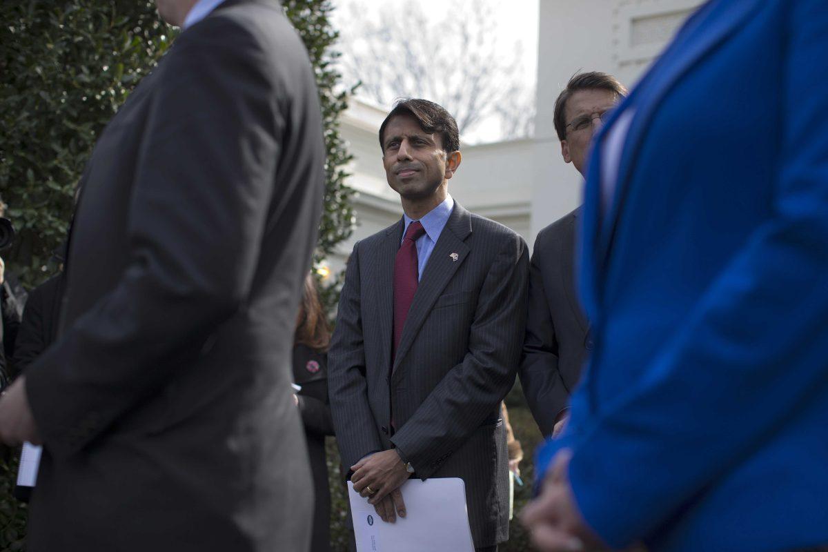 Louisiana Gov. Bobby Jindal listens as National Governors Association Chairman, Delaware Gov. Jack Markell, speaks with reporters outside the White House in Washington, Monday, Feb. 25, 2013, following their meeting with President Barack Obama. (AP Photo/Evan Vucci)