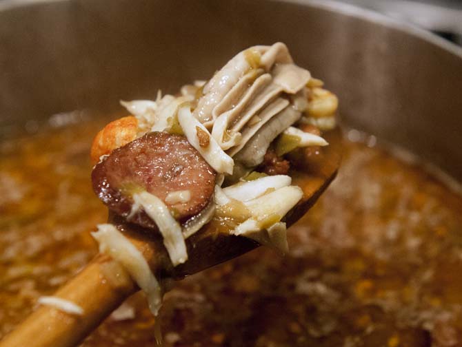 One of the cooking instructors holds up a spoon loaded with the different kinds of seafood in the gumbo, including oysters, shrimp, crawfish, and crab meat at the gumbo Viking cooking class at the Hilton Hotel on Jan. 31, 2013.
 