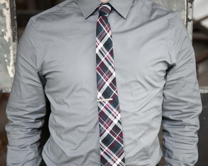 A tie bar, patterned tie and neutral colored shirt pair nicely with the recent warm weather.
 