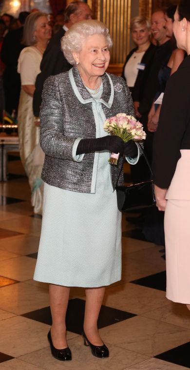 Britain's Queen Elizabeth II, Head of the Commonwealth receives a posy at a reception at Marlborough House, London Marlborough House, London Monday March 11, 2013. The Charter is an historic document which brings together, for the first time in the associations 64-year history, key declarations on Commonwealth principles. (AP Photo/ Philip Toscano/PA) UNITED KINGDOM OUT NO SALES NO ARCHIVE
 