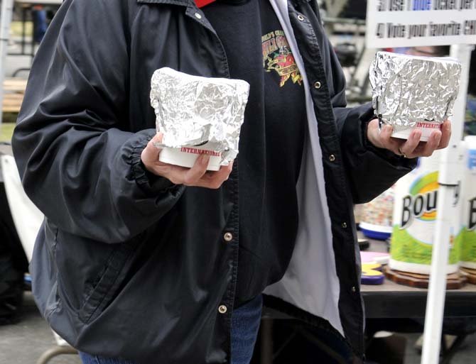 A chili cookoff participant brings samples of their chili to judges Saturday, March 9, 2013.
 