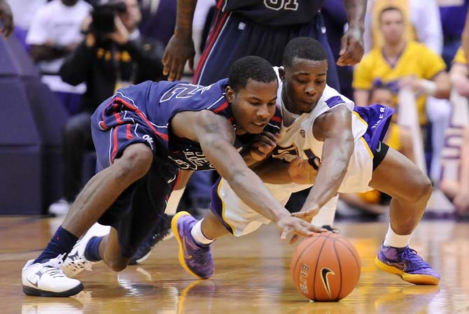 LSU sophomore guard Anthony Hickey (1) and Ole Miss sophomore guard Jarvis Summers (32) dive for the ball March 9, 2013 during the Tigers' 67-81 loss to the Rebels in the PMAC.
 