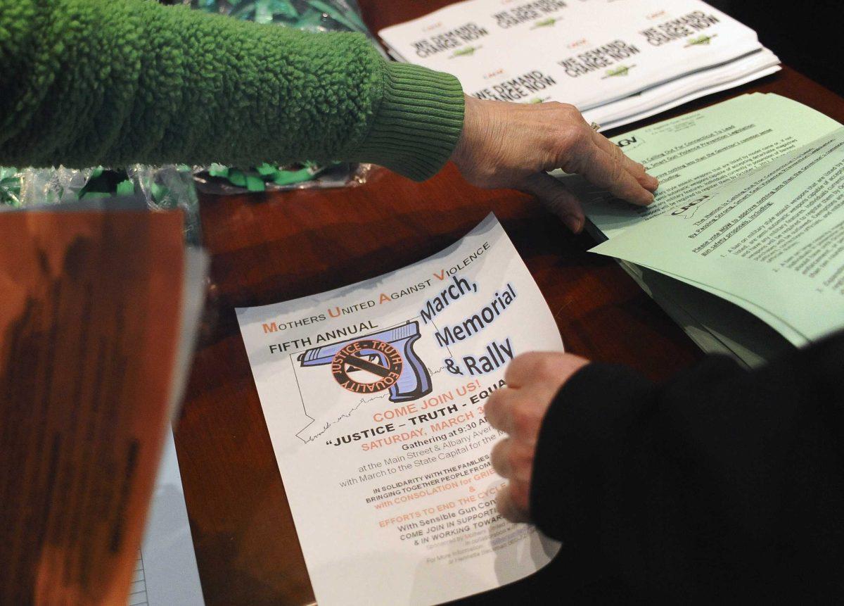 Supporters of gun control pick up reading material at a Connecticut Against Gun Violence meeting at the Legislative Office Building in Hartford, Conn., Wednesday, March 13, 2013. Both sides of the gun control issue are increasing pressure on Connecticut lawmakers who are close to voting on changes to state law stemming from the shooting deaths of 20 children and six educators at Sandy Hook Elementary School in Newtown. (AP Photo/Jessica Hill)