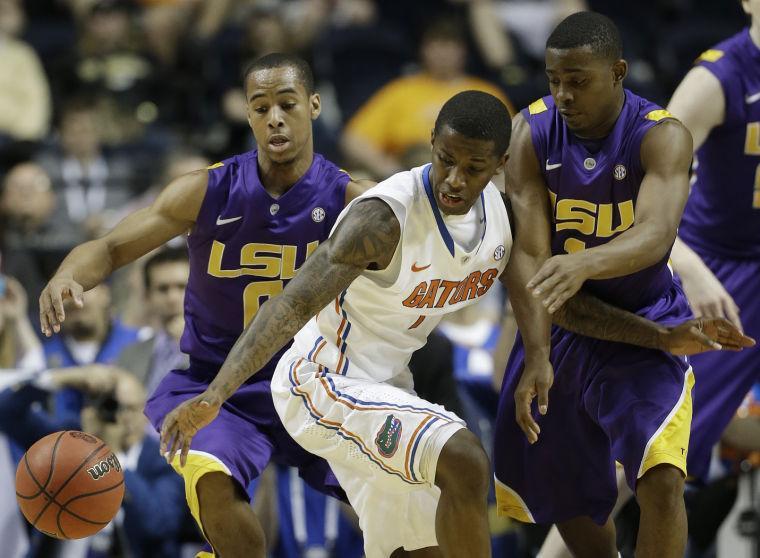 LSU guard Charles Carmouche (0), Florida guard Kenny Boynton (1), and LSU guard Anthony Hickey (1) vie for a loose ball during the second half of an NCAA college basketball game at the Southeastern Conference tournament, Friday, March 15, 2013, in Nashville, Tenn. (AP Photo/Dave Martin)
 