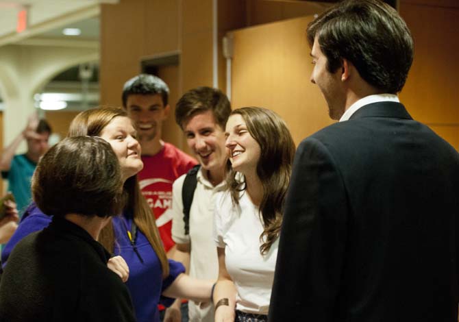 Newly reinstated Student Government Vice President Taylor Parks (left) and President John Woodard (right) smile and stand with supporters after UCourt's verdict Sunday, May 17, 2013.
 