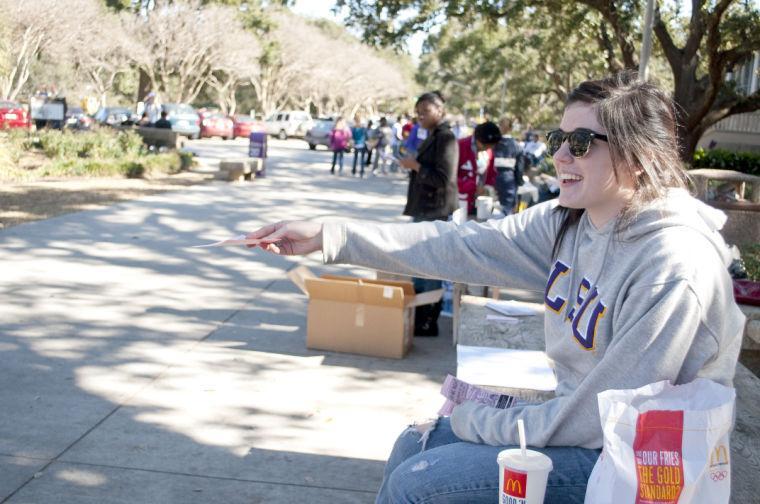 Tiffany Michel, Communication Studies sophomore, hands out fliers for Open Mic Night in Free Speech Alley.
 