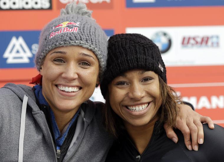 FILE- In this Nov. 9, 2012, file photo, USA's pilot Jazmine Fenlator, right, and brakewoman Lolo Jones pose for photographers after their second-place finish in the women's World Cup bobsled competition in Lake Placid, N.Y. Jones is hooked on bobsledding. Not only did the Olympic hurdler survive and enjoy her first season with the U.S. national team, she says she's committed to a run at the 2014 Sochi Games. (AP Photo/Mike Groll, File)
 