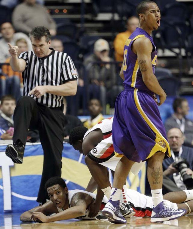 Georgia guard Charles Mann, on the court and LSU guard Charles Carmouche (0) react to an official's change of possession call during the second half of an NCAA college basketball game at the Southeastern Conference tournament, Thursday, March 14, 2013, in Nashville, Tenn. (AP Photo/Dave Martin)
 