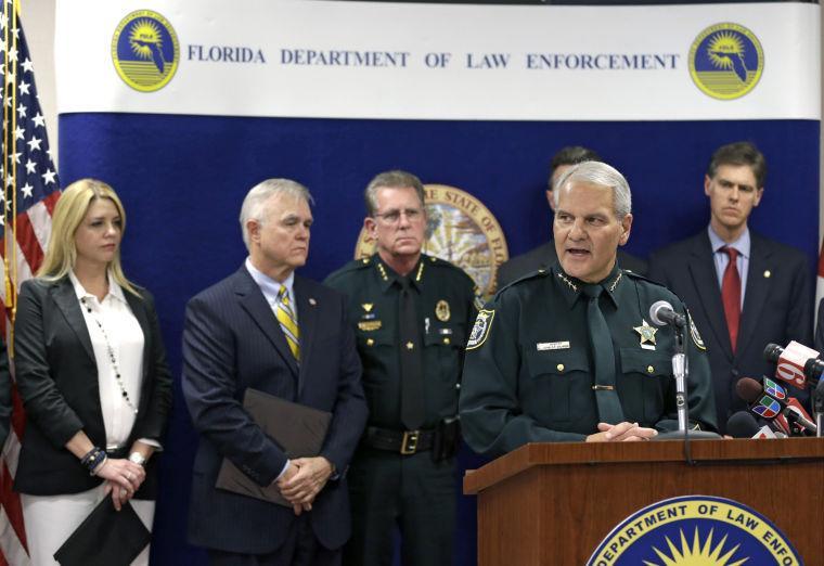 Seminole County Sheriff Don Eslinger, front right, speaks during a news conference Wednesday, March 13, 2013, in Orlando, Fla. Florida's lieutenant governor resigned and nearly 60 other people were charged in a widening scandal of a purported veterans charity that authorities said Wednesday was $300 million front for illegal gambling.(AP Photo/John Raoux)
 