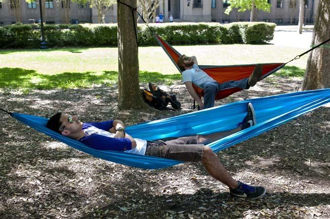 Photography sophomore Nick Martino (front) and History junior Connor Roberts (back) relax in their hammocks they set up in the quad Tuesday, March 19, 2013.
 