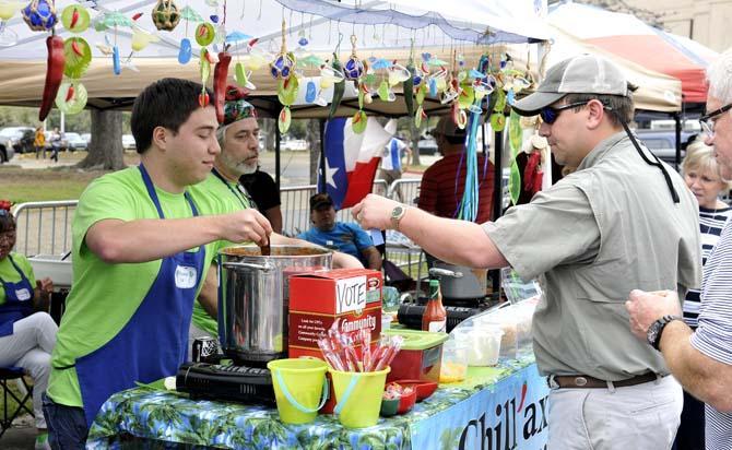 Robert Patterson, co-creator of "Chillaxing Chili," spoons a sample for a visitor to the chili cookoff on LSU's campus Saturday, March 9, 2013.
 