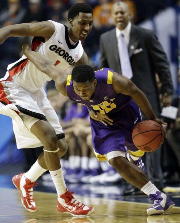 LSU guard Andre Stringer (10) dribbles past Georgia guard Kentavious Caldwell-Pope (1) during the first half of an NCAA college basketball game at the Southeastern Conference tournament, Thursday, March 14, 2013, in Nashville, Tenn. (AP Photo/Dave Martin)
 