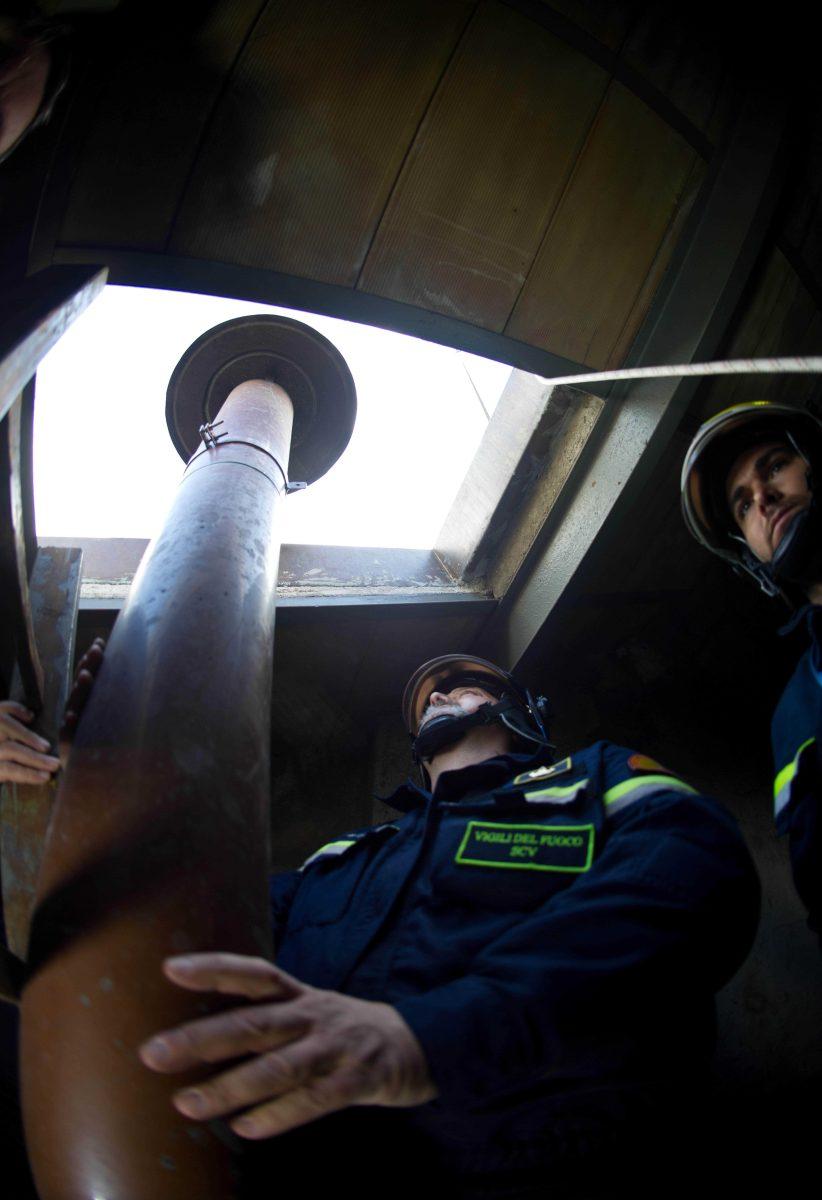 In this photo provided by the Vatican paper L'Osservatore Romano, taken on Saturday, March 9, 2013 and made available Monday, March 11, 2013, firefighters install the top of the Sistine Chapel chimney that will signal to the world that a new pope has been elected, at the Vatican. Cardinals gathered for their final day of talks Monday before the conclave to elect the next pope, amid debate over whether the Catholic Church needs more of a manager pope to clean up the Vatican or a pastoral pope who can inspire the faithful at a time of crisis. (AP Photo/L'Osservatore Romano, ho)