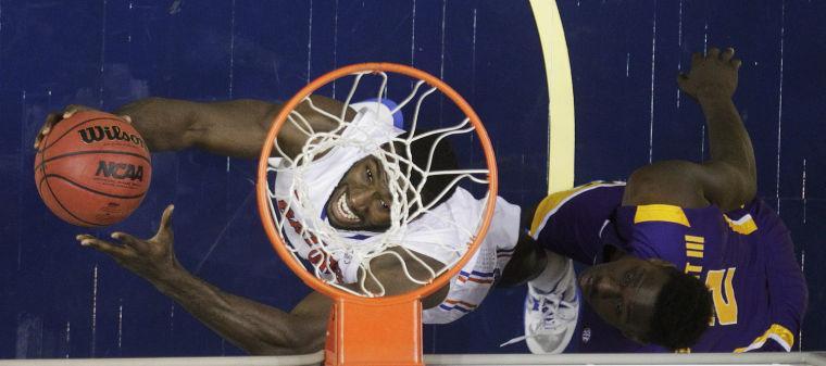 Florida center Patric Young (4), left, heads to the basket as LSU forward Johnny O'Bryant III (2) defends during the second half of an NCAA college basketball game at the Southeastern Conference tournament, Friday, March 15, 2013, in Nashville, Tenn. Florida won 80-58. (AP Photo/Dave Martin)
 