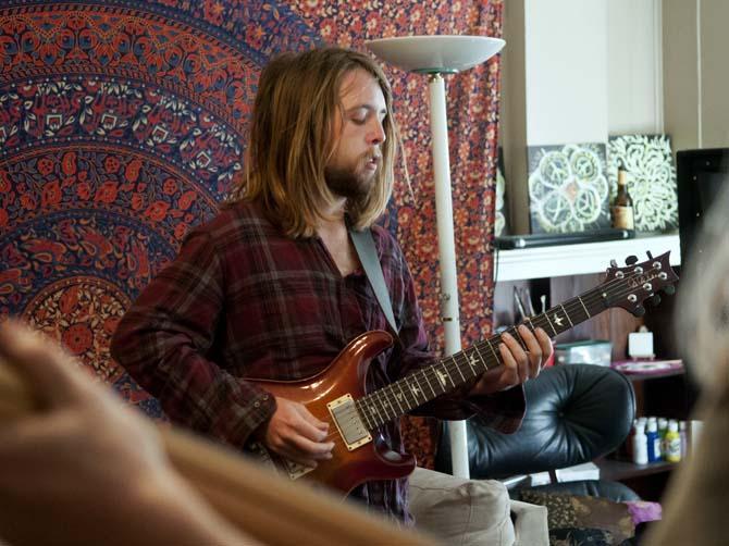 Robert Holden, guitarist in the band Trailer Hounds, jams out Sunday, March 24, 2013 during their band's practice at a friend's apartment on E. State Street.
 