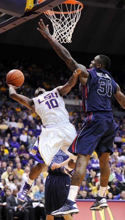 LSU junior guard Andre Stringer (10) shoots around Ole Miss senior forward Murphy Holloway (31) March 9, 2013 during the Tigers' 67-81 loss to the Rebels in the PMAC.
 