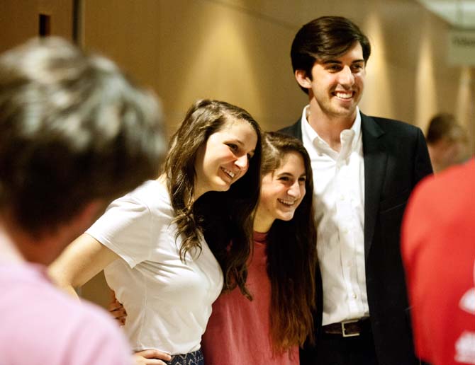 Newly reinstated Student Government Vice President Taylor Parks (left) and President John Woodard (right) smile and stand with a supporter after UCourt's verdict Sunday, May 17, 2013.
 