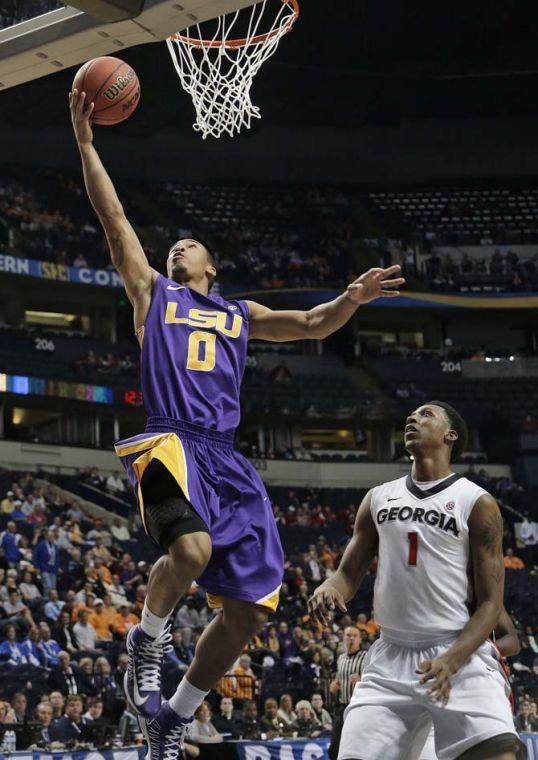 LSU guard Charles Carmouche (0) heads to the basket as Georgia guard Kentavious Caldwell-Pope (1) watches during the first half of an NCAA college basketball game at the Southeastern Conference tournament, Thursday, March 14, 2013, in Nashville, Tenn. (AP Photo/Dave Martin)
 