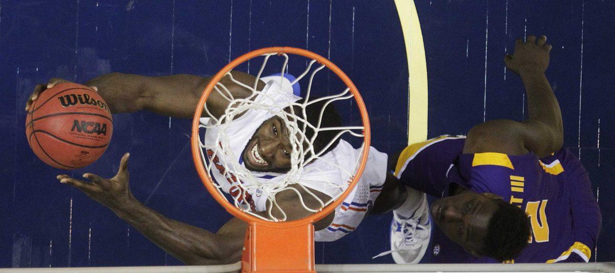 Florida center Patric Young (4), left, heads to the basket as LSU forward Johnny O'Bryant III (2) defends during the second half of an NCAA college basketball game at the Southeastern Conference tournament, Friday, March 15, 2013, in Nashville, Tenn. Florida won 80-58. (AP Photo/Dave Martin)