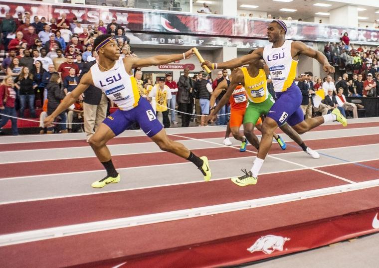 LSU's Cyril Grayson, right, hands off the baton to teammate Darrell Bush, left, on the final exchange of the 4x400-meter relay at the NCAA Division I Indoor Track and Field Championship in Fayetteville, Ark., Saturday, March 9, 2013. (AP Photo/April L. Brown)
 